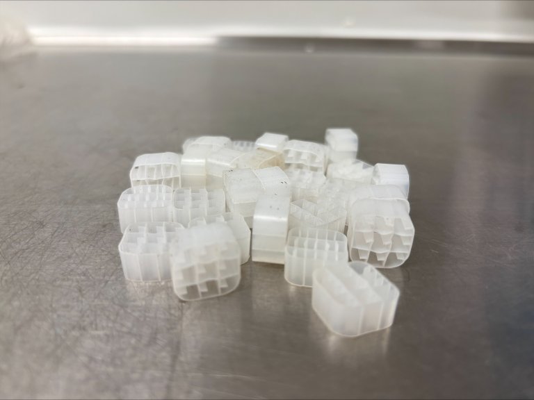 Små plastbiter fra Biowater Technology, kalt biofilm-bærere, som er mye brukt i systemer for vann- og avløpsbehandling. Disse gir en overflate der nyttige bakterier kan vokse og utføre sine oppgaver på en effektiv måte. Foto: Lu Feng