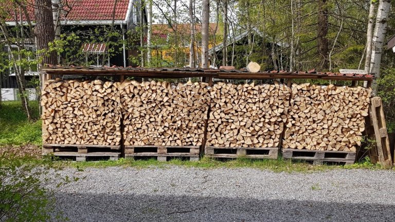 For å sjekke om veden er tørr nok kan du tørke et stykke av veden i en ovn i ett døgn. Hundre grader er greit, ikke mer! Differansen i vekt før og etter gir deg vannet som har fordampet ovnen. Bildet viser et fint oppsett for luftig tørking av ved under et enkelt tak i vårmånedene mars, april og mai. Foto: Eirik Nordhagen, NIBIO