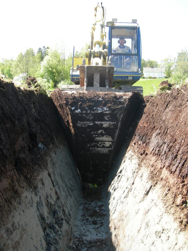 Grøftegraving med profilskuffe. Organisk jord over silthaldig lettleire er krevjande å drenera med tradisjonell røyrgrøfting åleine. Foto: Leif Trygve Berge, NLR Vest