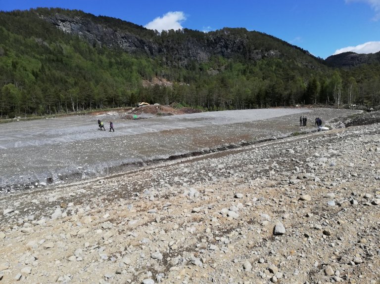 Tidlegare innmarksbeite med vekslande myr- og mineraljord som no er profilert og påkøyrt mineralmasse i Fjaler kommune i Vestland. I skogkanten er det ei avsetjing med mineralmasse som kan brukast til dekke. Foto: Synnøve Rivedal