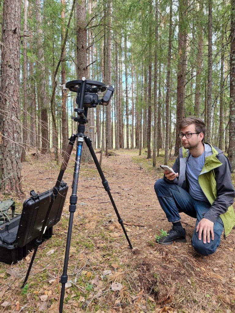 Bildetaking med eit hemisfærisk kamera, eit kamera med spesiell linse som brukas til å ta bilde av kronetaket. Basert på dette kan ein rekne ut andelen open himmel versus bladarealet og kan derfor brukast til å si noko om lysforholda. Dette biletet er tatt i ein kulturskog. Foto: Eivind Handegard
