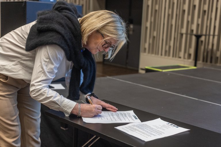 Hildegunn Norheim skriv under samarbeidsavtala med Kartverket, SSB og Miljødirektoratet. Avtala legg til rette for at samarbeidet om utvikling, uttesting, drift og distribusjon av grunnkartet kan halda fram og sikra at kartet er tilgjengeleg for alle som treng det i tiåra som kjem. Foto: Hege Ulfeng