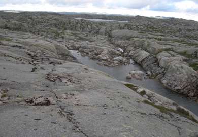 Svarberg med utsikt over en liten bukt
